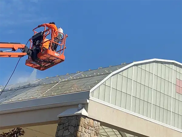 Engelmann Construction workers washing and waterproofing the roof towards the front of a church